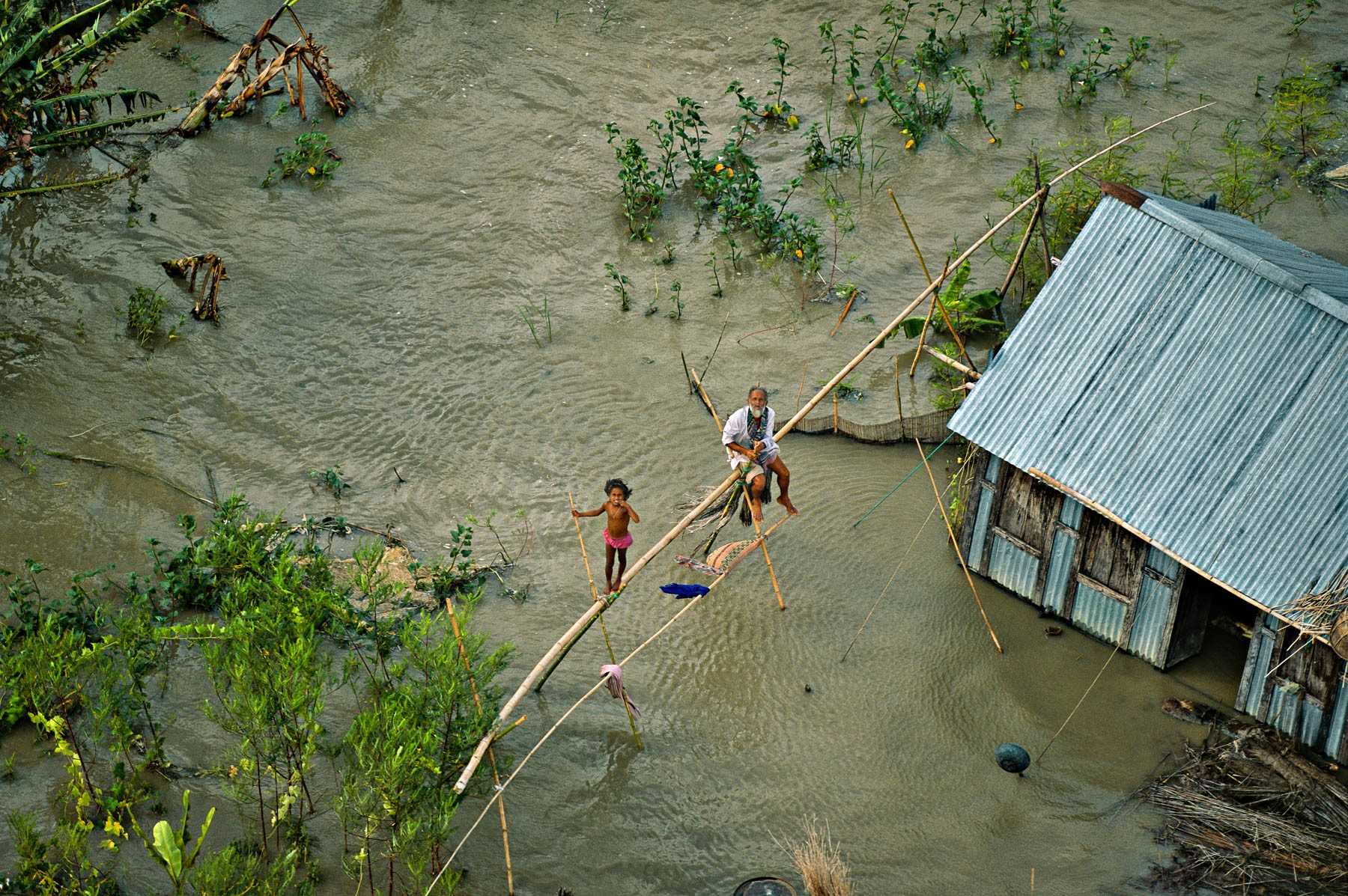 Une famille naufragée après l’inondation de sa maison au sud de Dakha (Bangladesh) © Yann Arthus-Bertrand