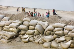 Barrage édifié en sacs de sable sur le delta du Gange au Bangladesh pour contrer la montée des eaux (Chittagong District). Si l’on ne parvient pas à réduire nos émissions de gaz à effet de serre, de nombreux territoires seront recouverts par les océans. © Yann Arthus-Bertrand